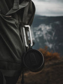 VUUS Zero aluminum clip attached to an outdoor backpack to carry water bottles and gear during a hike.